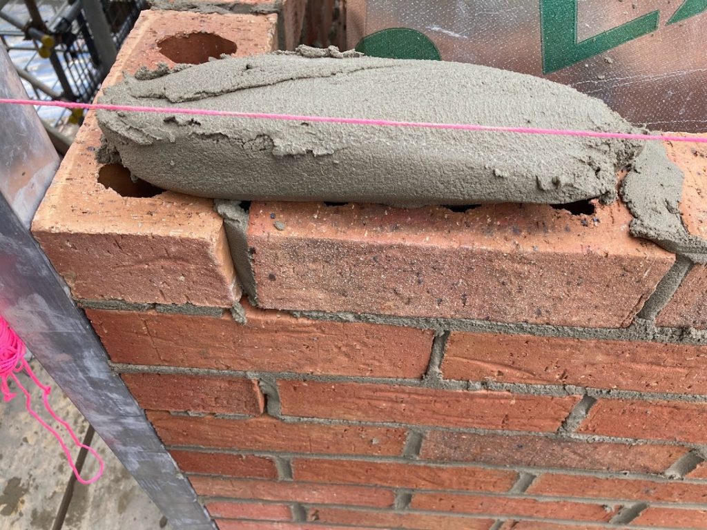 cement spread on brick wall
